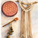 Illustration à l'aquarelle d'objets rituels : un tambour chamanique avec fleur de vie, une tenture en macramé et un hochet.